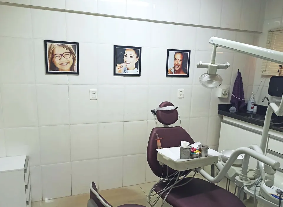 Consultório com quadros de sorrisos na parede