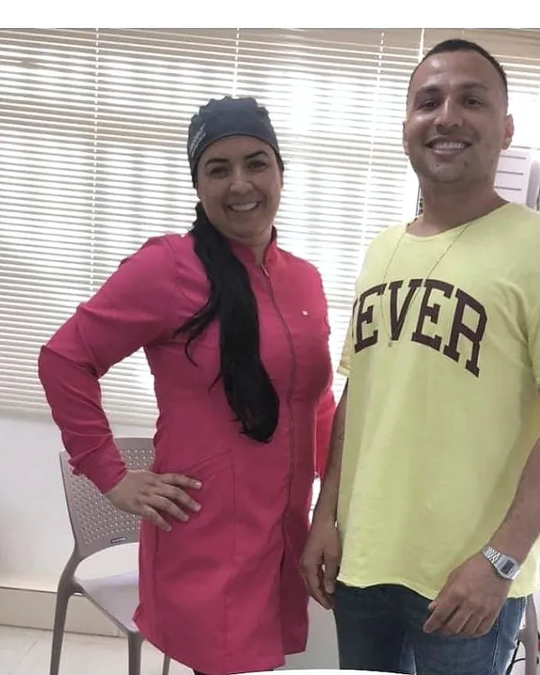 Maicon ao lado da dentista no início do clareamento